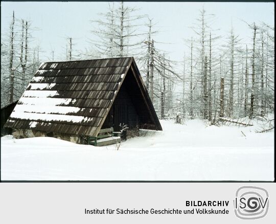 Schutzhütte und abgestorbenen Nadelbäume im verschneiten Hochmoor