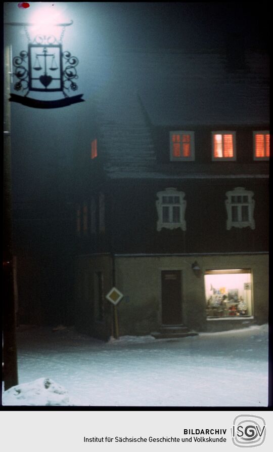 Blick über die verschneite Hauptstraße in Geising bei Nacht
