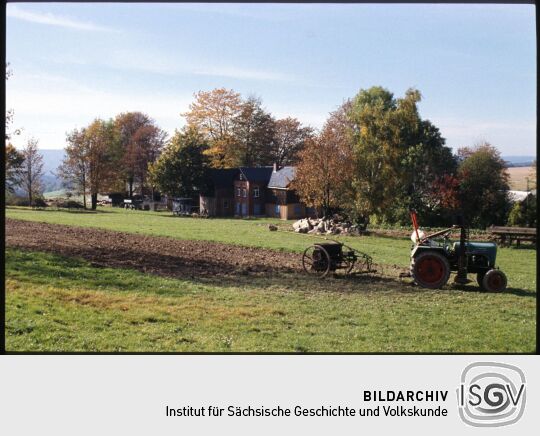 Traktor auf einem teilweise gepflügten Feld im Freilichtmuseum Landwüst