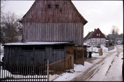 Bild: Blick durch die verschneite Röderstraße in Großröhrsdorf mit der Kirche im Hintergrund.