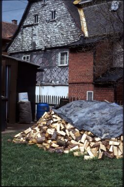 Bild: Brennholzhaufen vor einer verschieferten Fassade in Jonsdorf