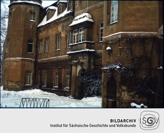 Blick zu einem Eingang am verschneiten Schloss Hermsdorf