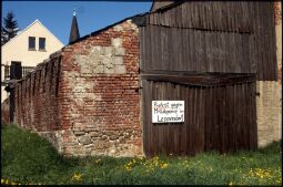 Bild: Protestschild gegen eine Mülldeponie am Tor einer zum Teil verfallenen Scheune in Leppersdorf