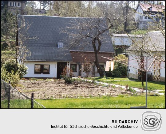 Umgebindehaus in Jonsdorf, im Garten vor dem Haus steht ein Wäscheständer