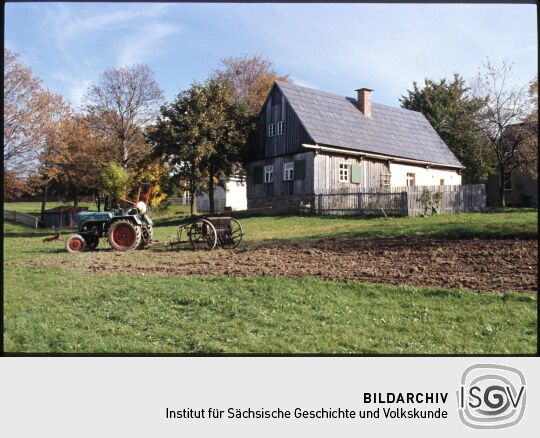 Historischer Traktor vor einem Gebäude des Freilichtmuseums Landwüst