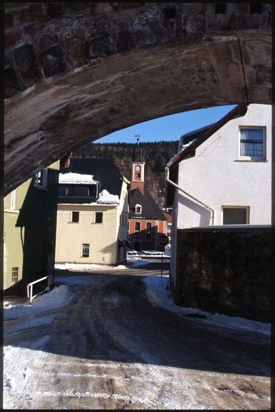 Blick durch einen Bogen des Eisenbahnviadukts zur George-Bähr-Kirche in Schmeideberg