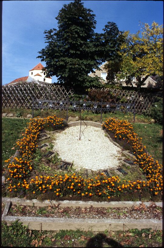 Blumengeschmuckte Sonnenuhr in Schönberg, im Hintergrund das Schloss