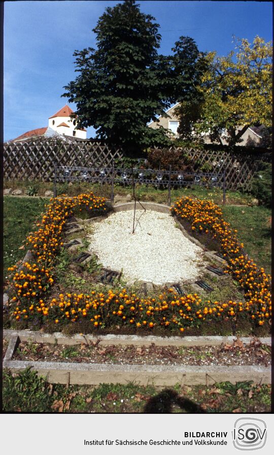 Blumengeschmuckte Sonnenuhr in Schönberg, im Hintergrund das Schloss
