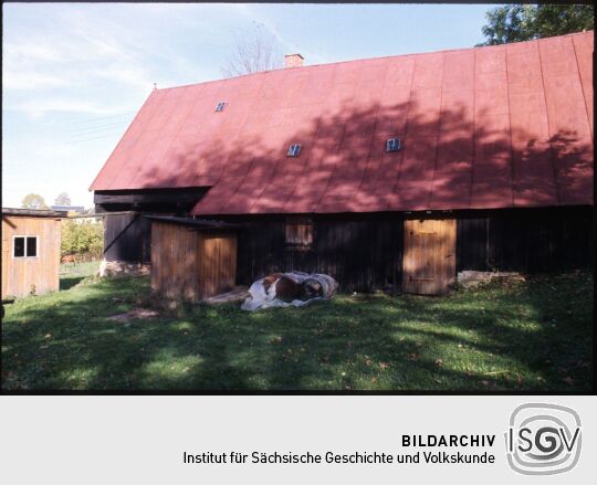 Holzgebäude eines Bauernhofs mit einem blechgedecktem Dach beim Freiluftmuseum Landwüst