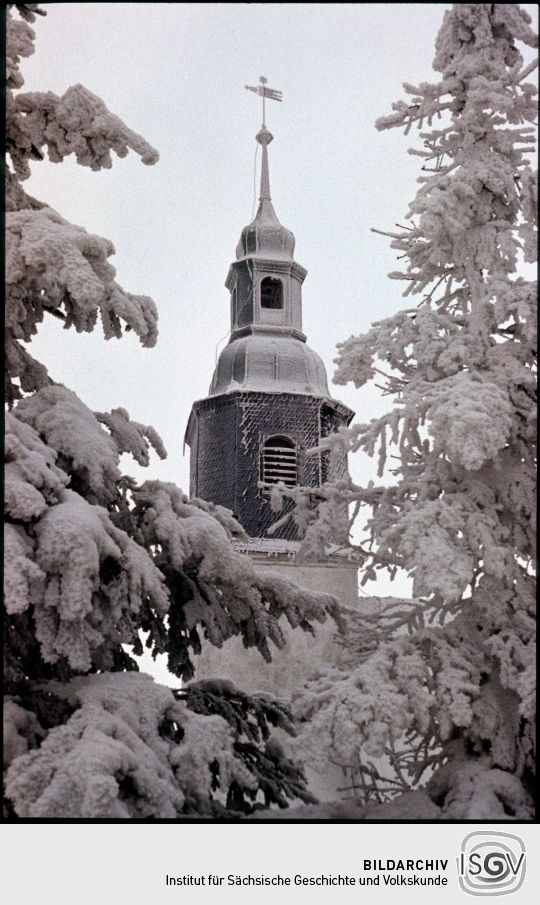 Blick zum verschneiten Kirchturm in Schellerhau