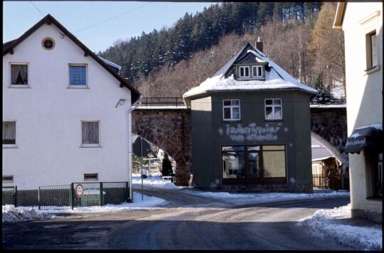 Gebäude vor dem Eisenbahnviadukt in Schmiedeberg im Winter