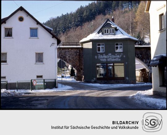 Gebäude vor dem Eisenbahnviadukt in Schmiedeberg im Winter