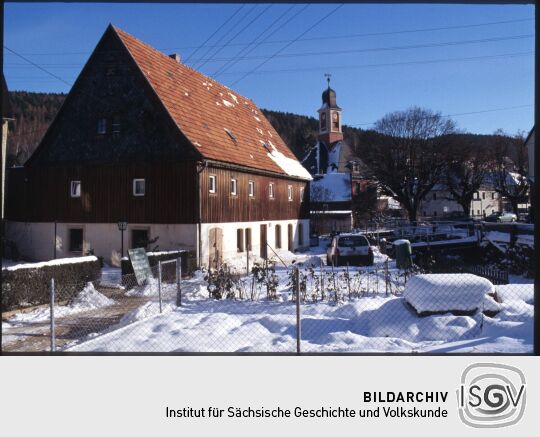 Blick auf das verschneite Schmiedeberg mit der Kirche im Hintergrund