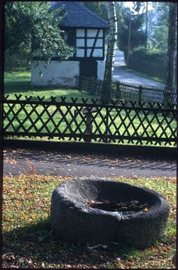 Bild: Steinernes Becken (?) und ein Fachwerkgebäude in Sachsgrün