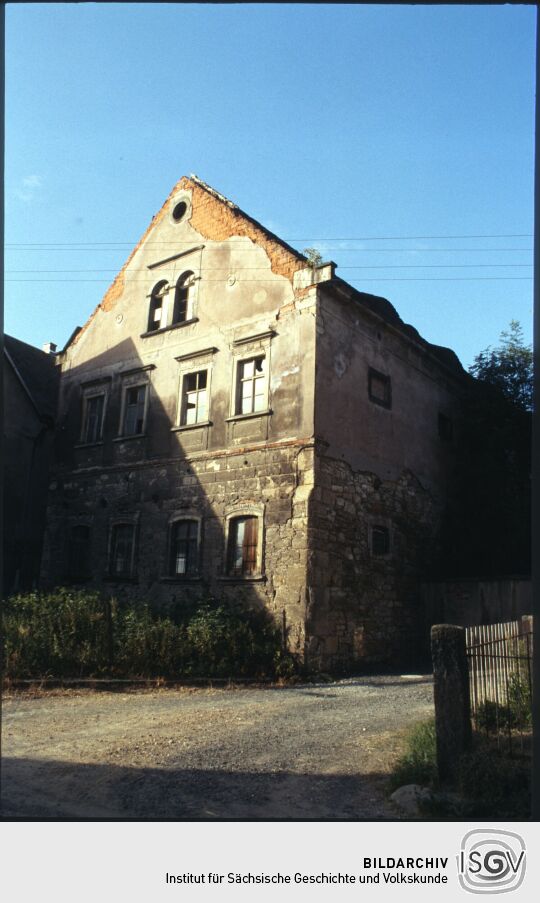 Baufälliges Wohngebäude eines Bauernhofs mit großflächig abgeplatztem Putz gegenüber des Gasthofes in Sobrigau