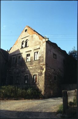 Bild: Baufälliges Wohngebäude eines Bauernhofs mit großflächig abgeplatztem Putz gegenüber des Gasthofes in Sobrigau
