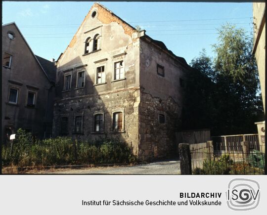 Baufälliges Wohngebäude eines Bauernhofs mit großflächig abgeplatztem Putz gegenüber des Gasthofes in Sobrigau