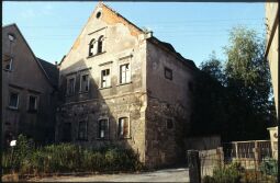 Bild: Baufälliges Wohngebäude eines Bauernhofs mit großflächig abgeplatztem Putz gegenüber des Gasthofes in Sobrigau