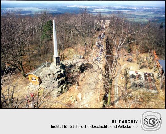 Blick vom Aussichtsturm auf den Gipfel des Keulenberges mit dem Obelisken, der Ruine des Bergschlösschens und gastronomischen Einrichtungen