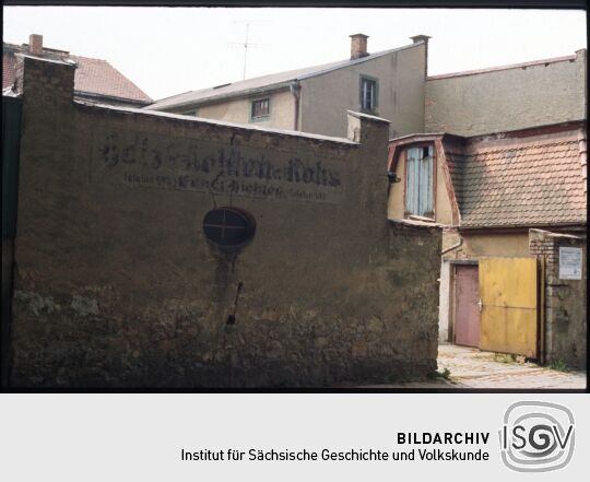 Historisches Geschäftsschild an einer Mauer in Bischofswerda