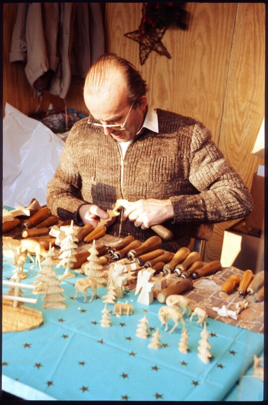 Schnitzer beim Herstellen von Holzfiguren am Dresdner Altmarkt