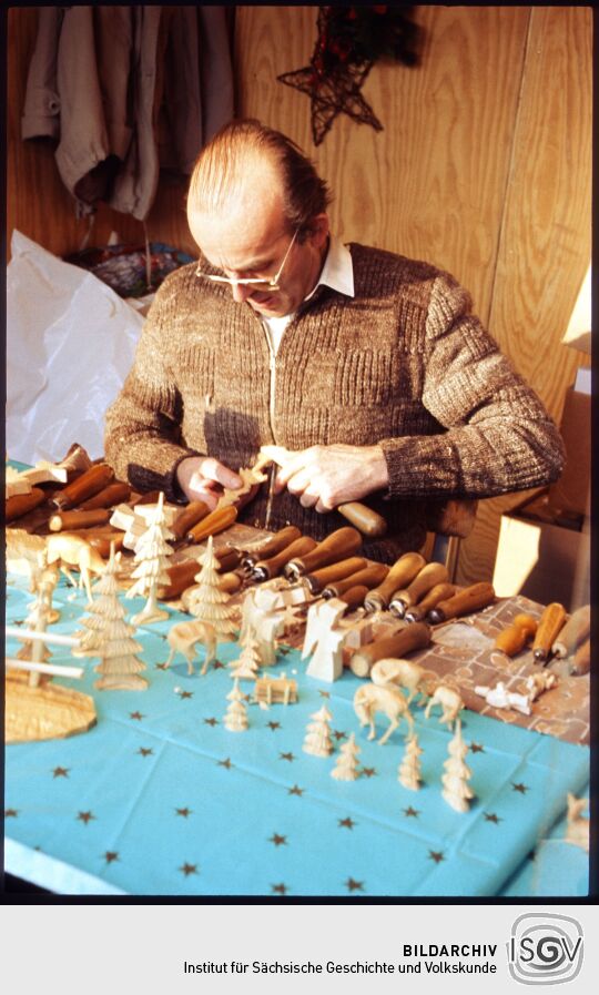 Schnitzer beim Herstellen von Holzfiguren am Dresdner Altmarkt
