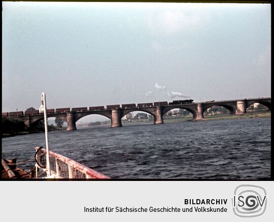Blick von der Elbe auf die Brücke in Pirna mit einem Güterzug