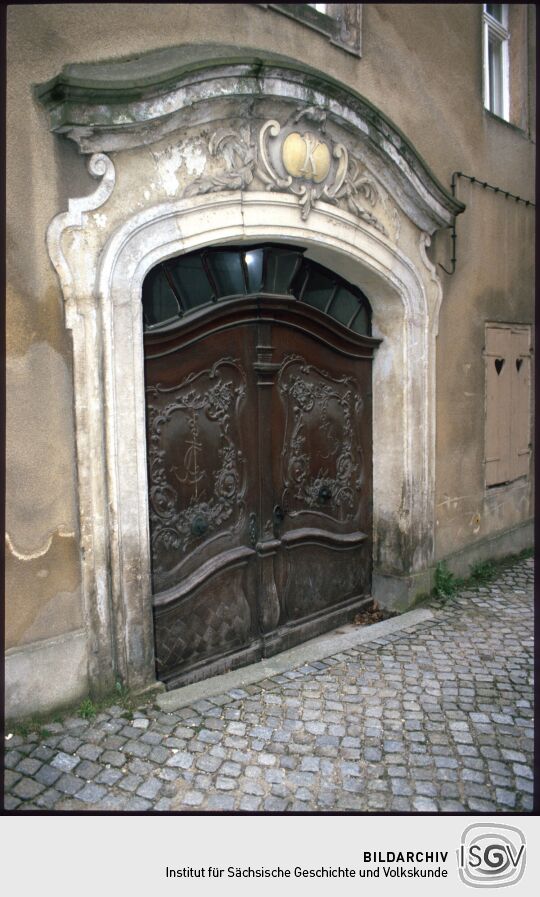 Portal des Tuchhandelshauses Kind mit spätbarocker Steineinfassung und Türblättern mit reichen Schnitzerein (später translociert)