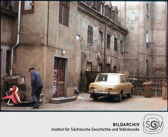 Hinterhof der Adlergasse 26-28 mit einem parkenden Auto und den Resten eines Motorrollers