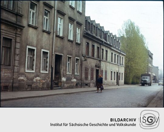 Blick auf die Gebäude Adlergasse 26-32 in der Dresdner Friedrichstadt, davor eine Frau mit Kopftuch