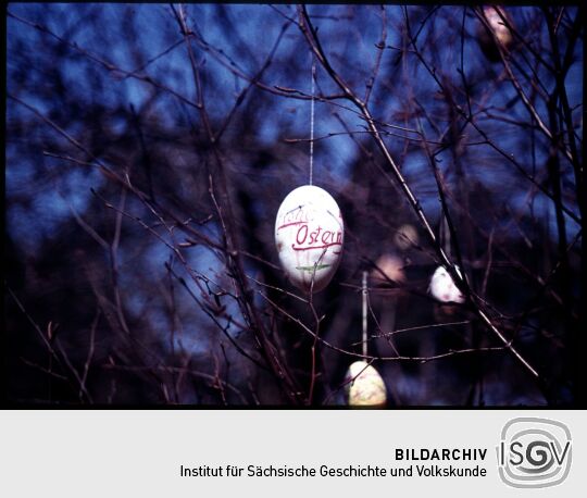 Ein Osterei mit der Aufschrift 'Frohe Ostern' an einem Osterbaum in Gohrisch