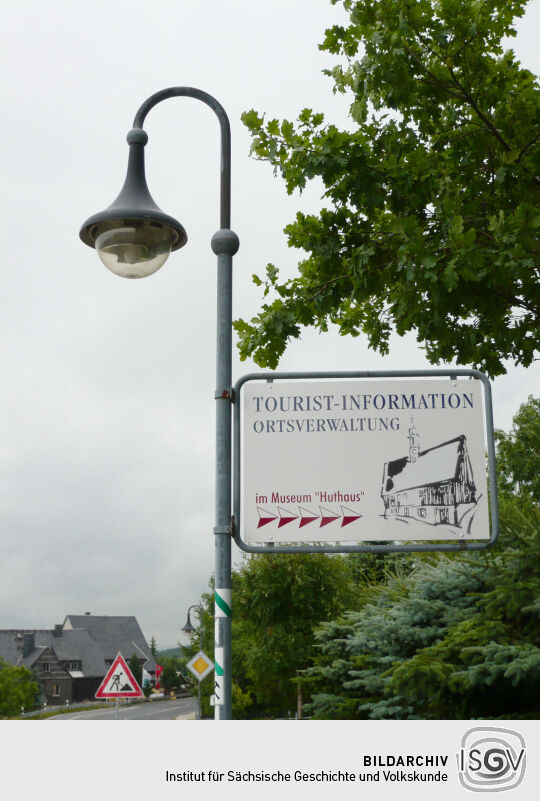 Hinweistafel auf die Touristinformation im Museum Huthaus in Zinnwald