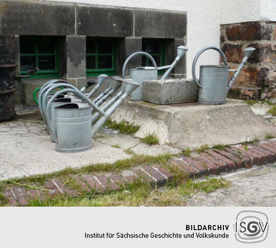 Gießkannen zur Pflege der Gräber auf dem Friedhof in Zinnwald