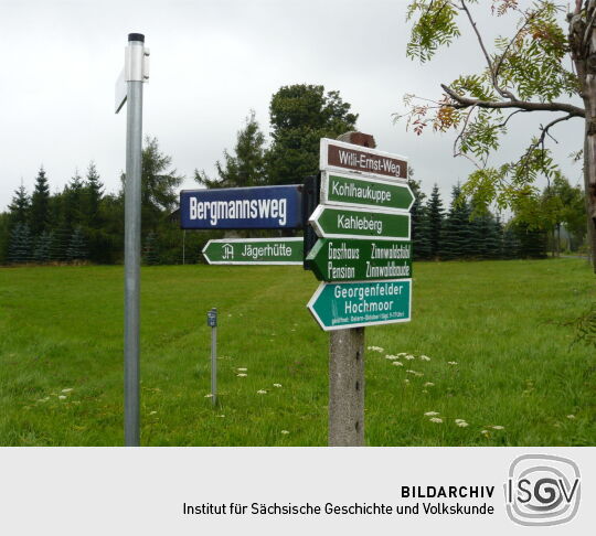 Touristische Hinweischilder an einer Wegegabelung in Zinnwald